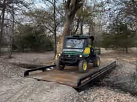 A utility vehicle crossing a steel bridge with timber decking.