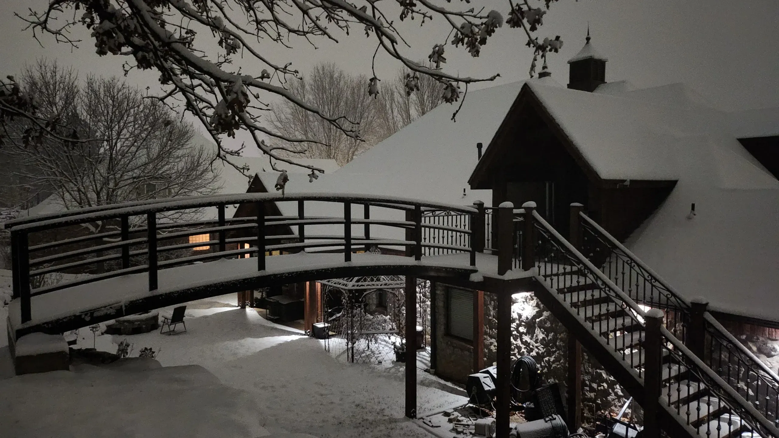 pedestrian bridge with wooden deck and metal rails in snowy setting