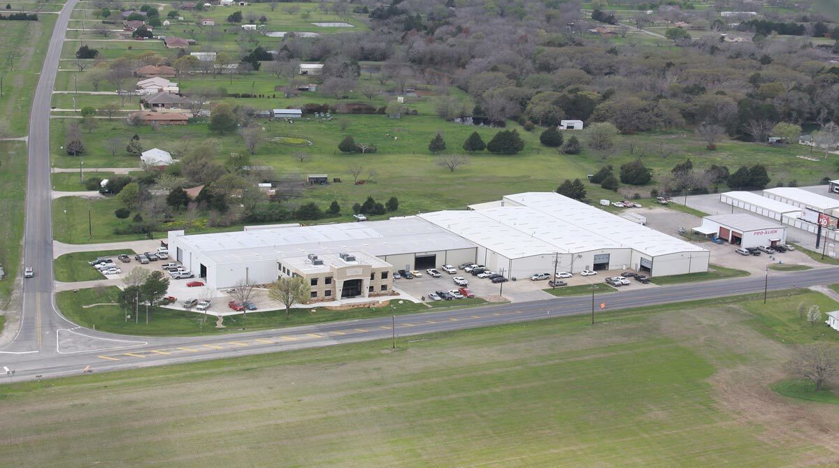 Aerial view of commercial buildings near road, highlighting layout and surroundings.