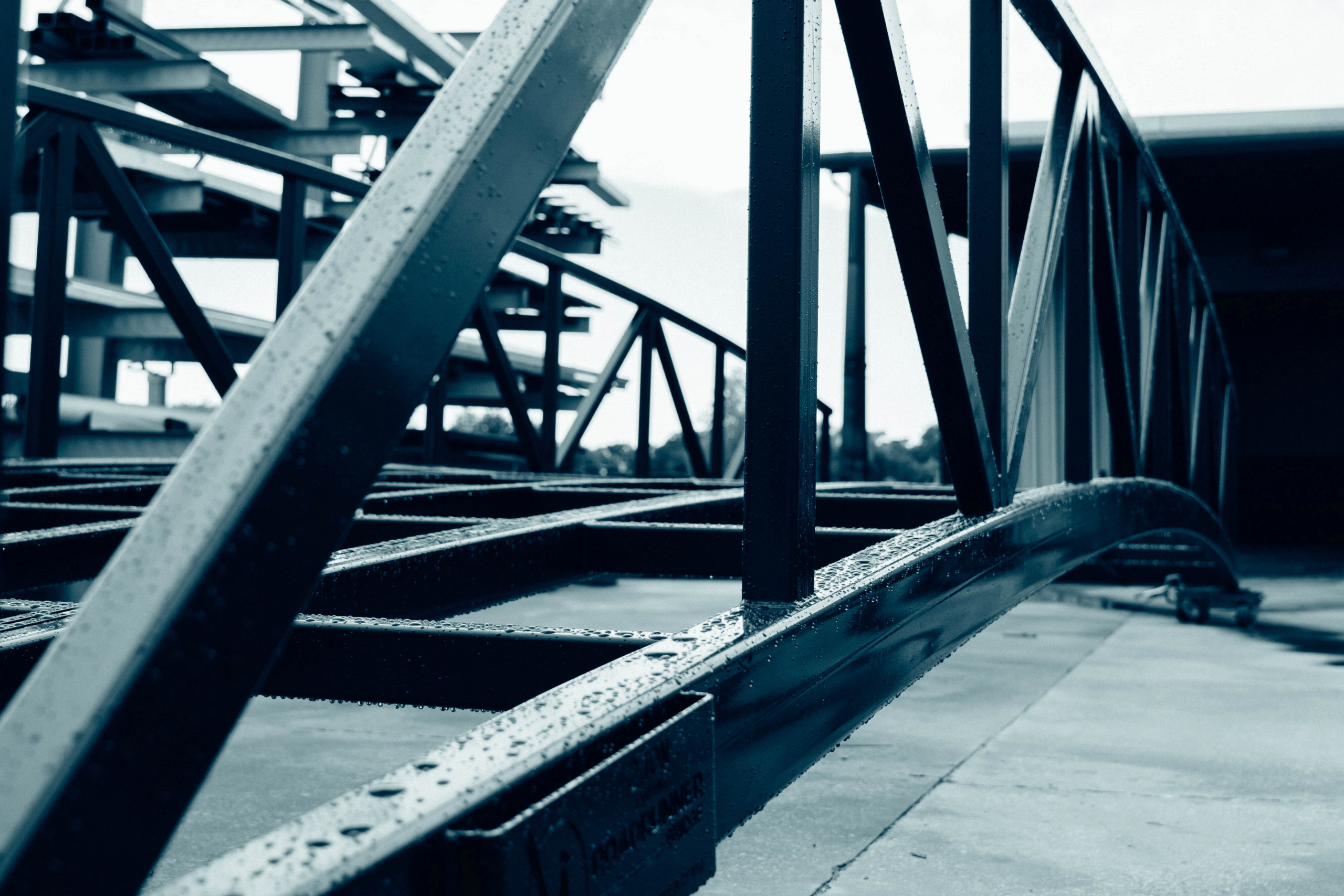 Warren truss bridge with painted finish, for pedestrian use and under construction.