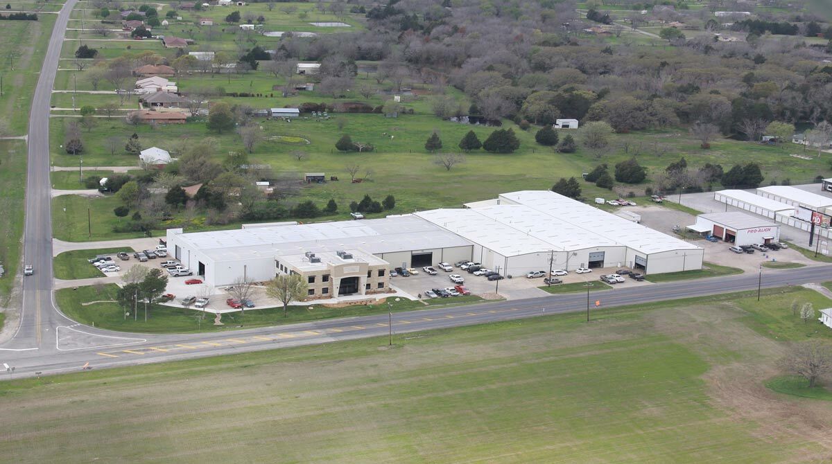 Aerial view of commercial buildings near road, highlighting layout and surroundings.